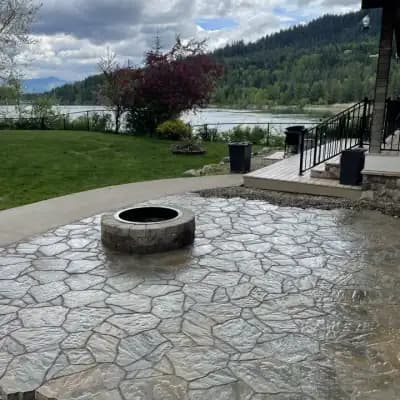 Lakeside stone patio and fire pit by CLR Landscape
