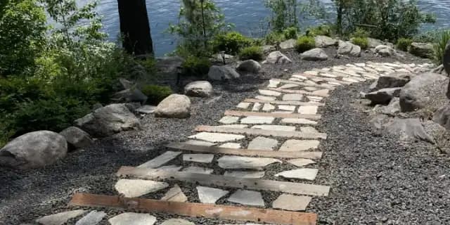 Stone garden path overlooking the lake by CLR Landscape